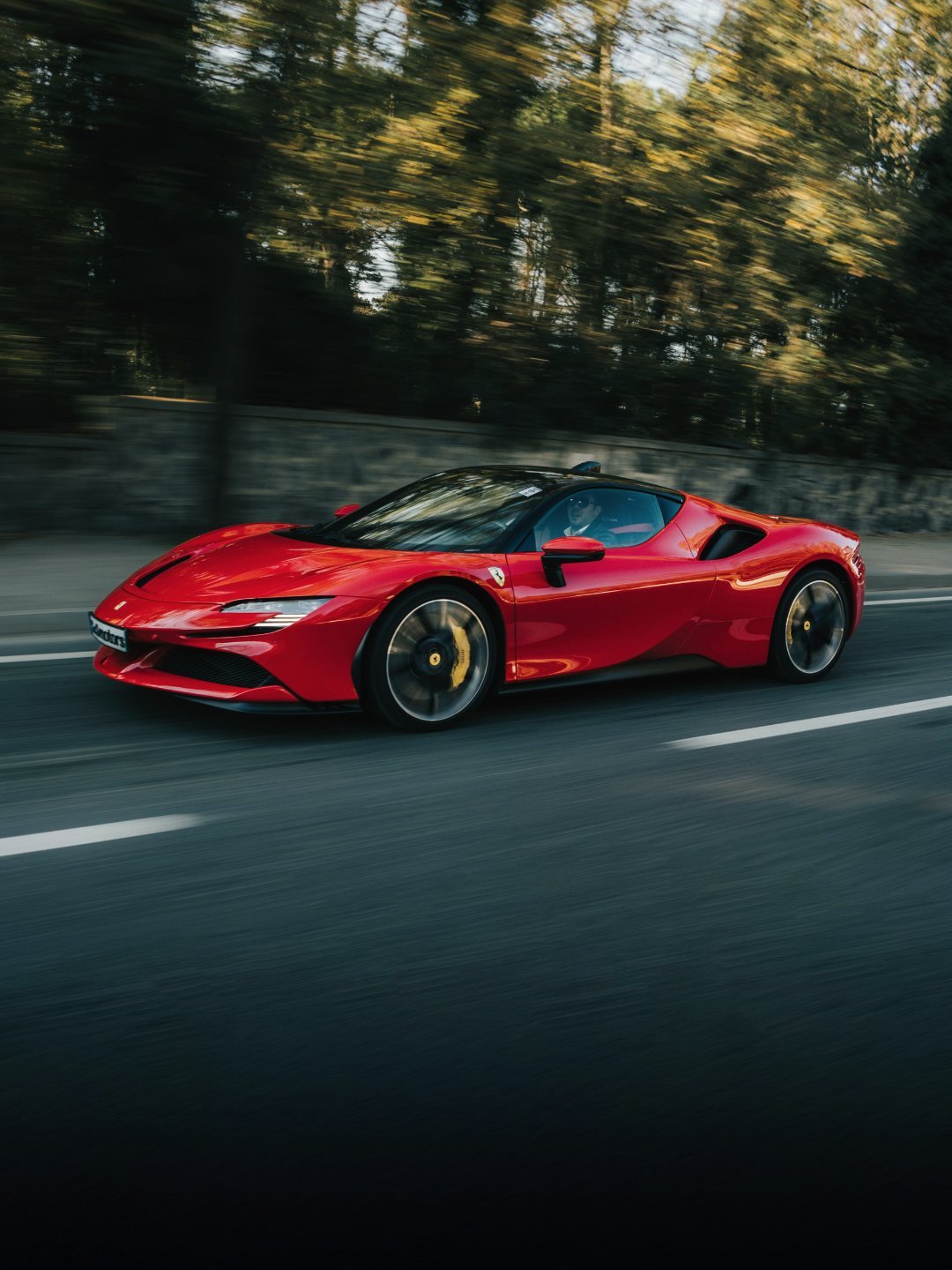 A red Ferrari on an open highway at speed